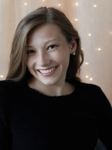A woman wearing a black shirt smiles.